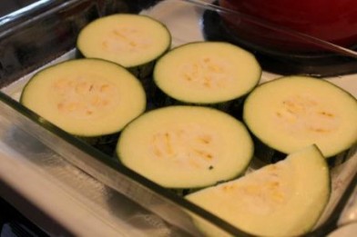 Layer half the zucchini slices in the pan.